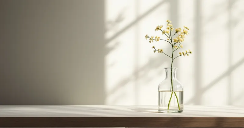 Single flower stem in a plain glass vase in soft daylight (illustration)
