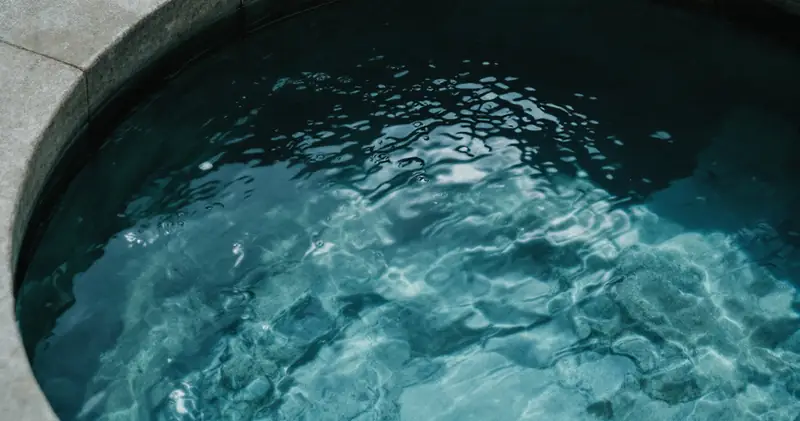 Still clear water in a smooth stone basin (illustration)
